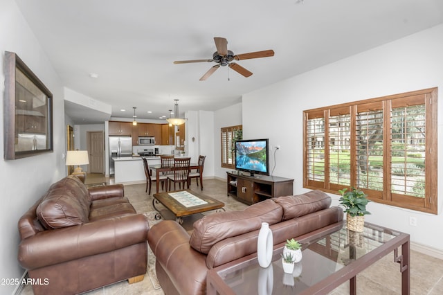 living room featuring recessed lighting, a ceiling fan, and baseboards