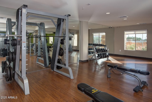 gym featuring visible vents, baseboards, and wood finished floors