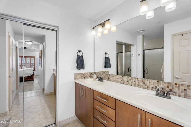 bathroom featuring visible vents, backsplash, connected bathroom, and a sink