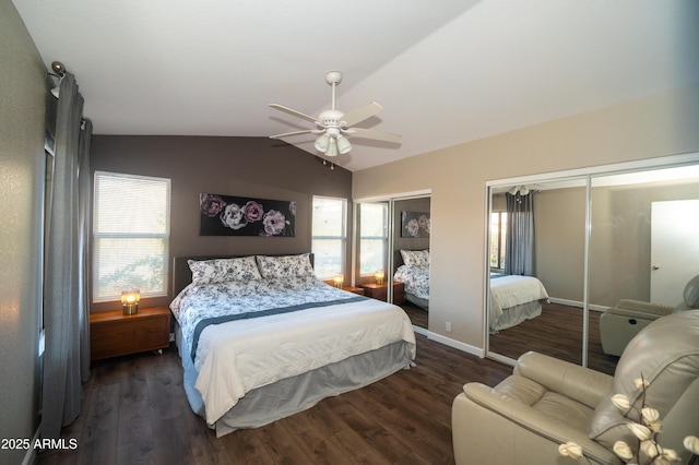 bedroom featuring lofted ceiling, two closets, dark wood-type flooring, and ceiling fan