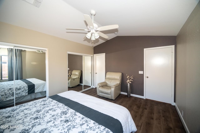 bedroom with vaulted ceiling, two closets, ceiling fan, and dark hardwood / wood-style flooring