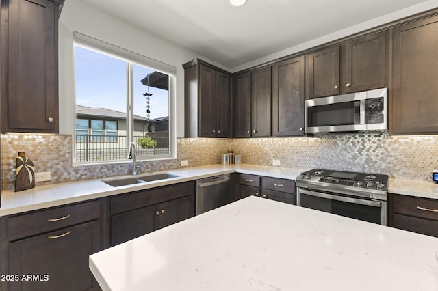 13204 W Via Dona Rd, Peoria, AZ 85383 - kitchen with dark brown cabinetry, a sink, stainless steel appliances, and tasteful backsplash