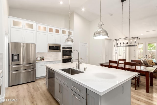 18614 E Oriole Way, Queen Creek, AZ 85142 - kitchen featuring appliances with stainless steel finishes, a sink, backsplash, light wood-style flooring, and high vaulted ceiling