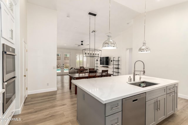 18614 E Oriole Way, Queen Creek, AZ 85142 - kitchen featuring stainless steel appliances, a sink, gray cabinets, light wood finished floors, and lofted ceiling