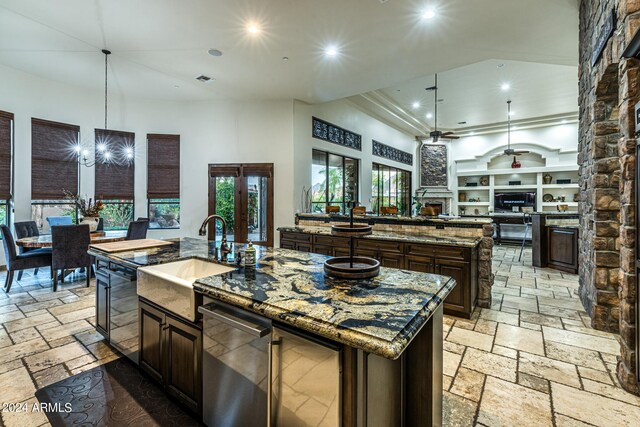 living room featuring decorative columns, a high ceiling, built in features, ceiling fan, and a fireplace