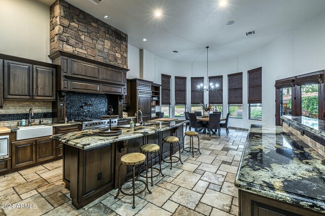 kitchen featuring a stone fireplace, built in shelves, a high ceiling, and ceiling fan