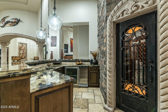 living room featuring light tile patterned flooring, a fireplace, ceiling fan, and a high ceiling