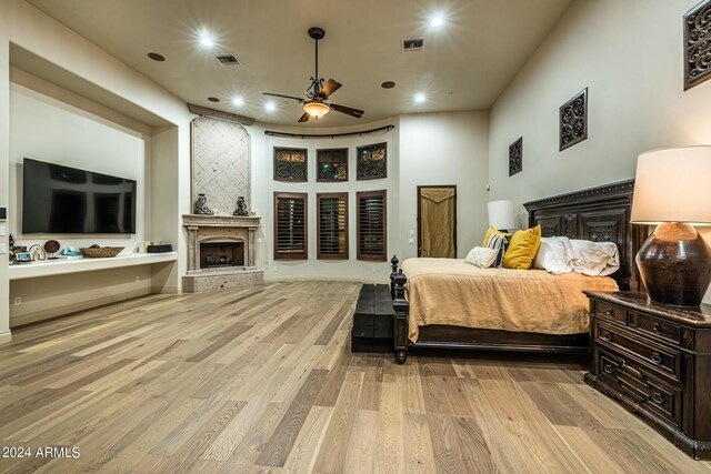 kitchen with a towering ceiling, light stone countertops, sink, and a center island with sink