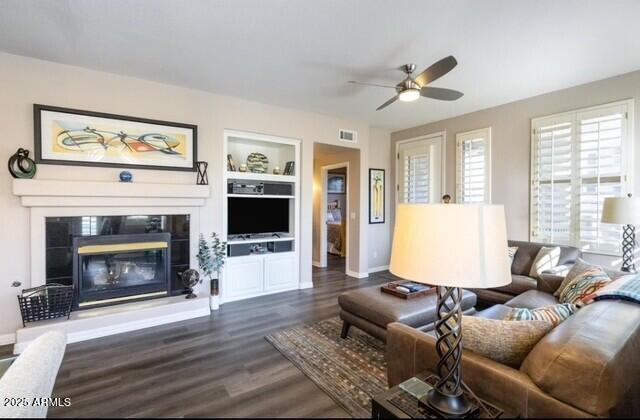 15221 N Clubgate Dr Unit 2096, Scottsdale, AZ 85254 - living room featuring ceiling fan, built in shelves, dark wood finished floors, and a glass covered fireplace