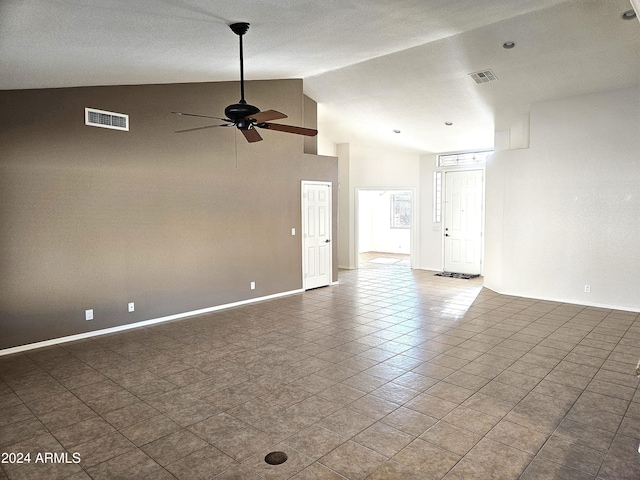 spare room with dark tile patterned flooring, high vaulted ceiling, and ceiling fan