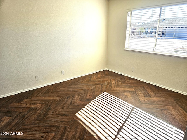 unfurnished room featuring dark parquet flooring