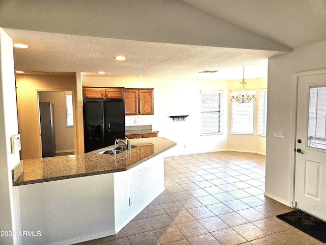 kitchen featuring black fridge with ice dispenser, sink, pendant lighting, an inviting chandelier, and light tile patterned flooring