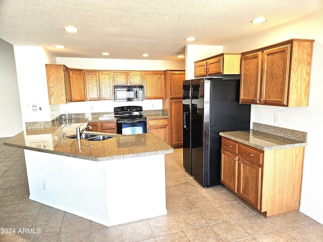 kitchen featuring black appliances, kitchen peninsula, sink, and light tile patterned floors