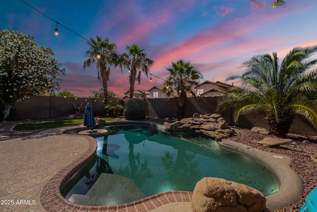 11526 W Bermuda Dr, Avondale, AZ 85392 - pool at dusk featuring a fenced backyard and a patio