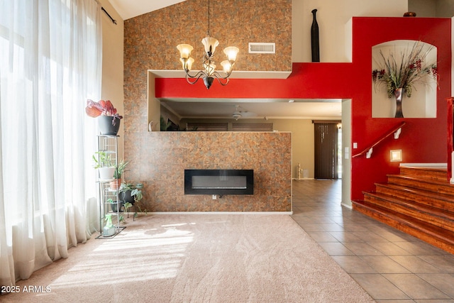 11526 W Bermuda Dr, Avondale, AZ 85392 - unfurnished living room with high vaulted ceiling, tile patterned flooring, a glass covered fireplace, a chandelier, and stairway