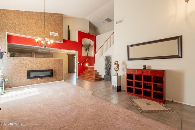 11526 W Bermuda Dr, Avondale, AZ 85392 - living room with tile patterned flooring, stairway, baseboards, a chandelier, and high vaulted ceiling