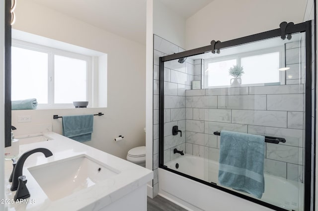 full bathroom featuring vanity, toilet, enclosed tub / shower combo, and hardwood / wood-style floors