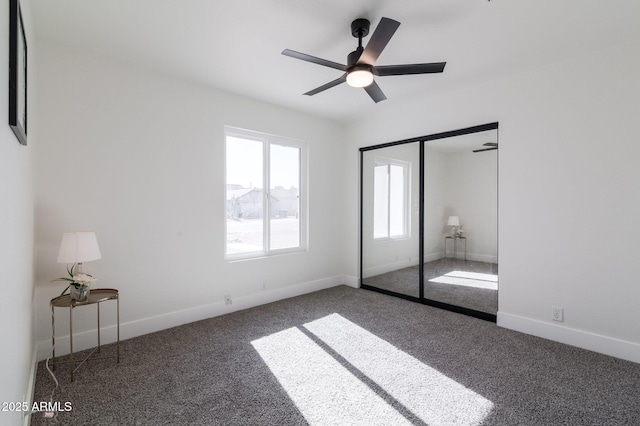 unfurnished bedroom with dark carpet, a closet, and ceiling fan