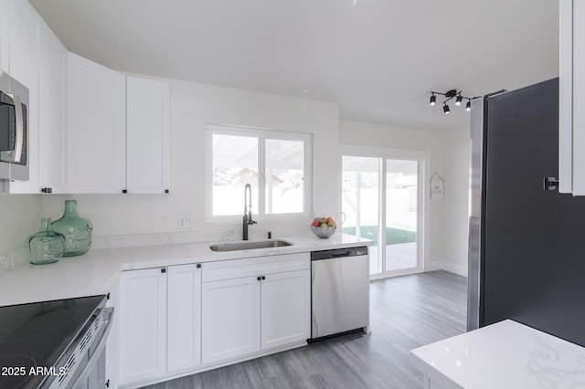 kitchen with sink, white cabinetry, and stainless steel appliances