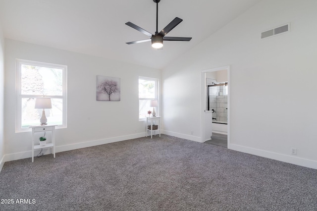 unfurnished bedroom featuring dark colored carpet, multiple windows, and ensuite bathroom