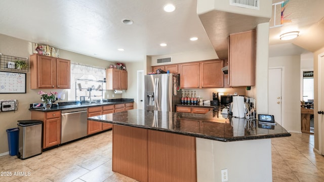 7274 W State Ave, Glendale, AZ 85303 - kitchen with stainless steel appliances, a peninsula, plenty of natural light, dark stone counters, and recessed lighting