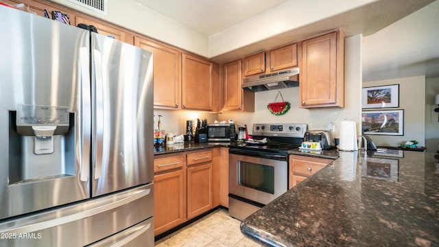 7274 W State Ave, Glendale, AZ 85303 - kitchen with stainless steel appliances, under cabinet range hood, light tile patterned floors, and dark stone counters