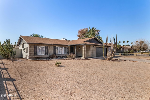 ranch-style house with concrete driveway, brick siding, and an attached garage