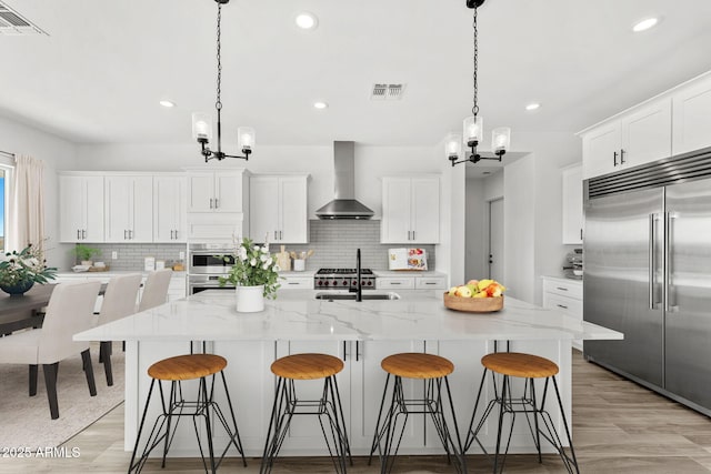 13947 E Barwick Dr, Scottsdale, AZ 85262 - kitchen with an inviting chandelier, visible vents, stainless steel appliances, and wall chimney exhaust hood
