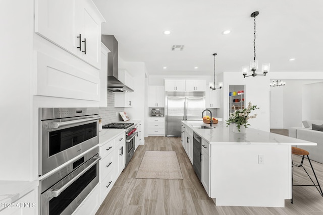 13947 E Barwick Dr, Scottsdale, AZ 85262 - kitchen featuring decorative backsplash, visible vents, wall chimney range hood, a notable chandelier, and premium appliances