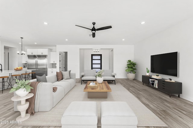 13947 E Barwick Dr, Scottsdale, AZ 85262 - living room with baseboards, recessed lighting, light wood-style floors, and ceiling fan with notable chandelier