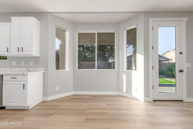 interior space with baseboards and light wood-style floors