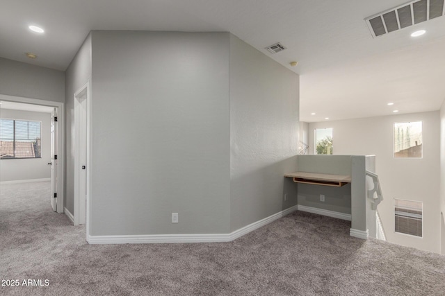 hallway with baseboards, carpet flooring, and visible vents