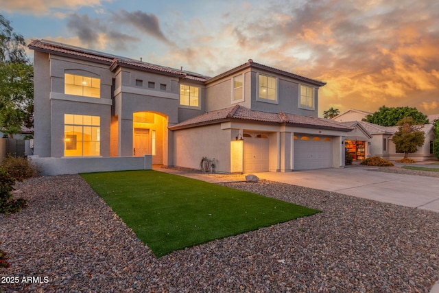 view of front facade featuring a tile roof, a garage, stucco siding, concrete driveway, and a lawn
