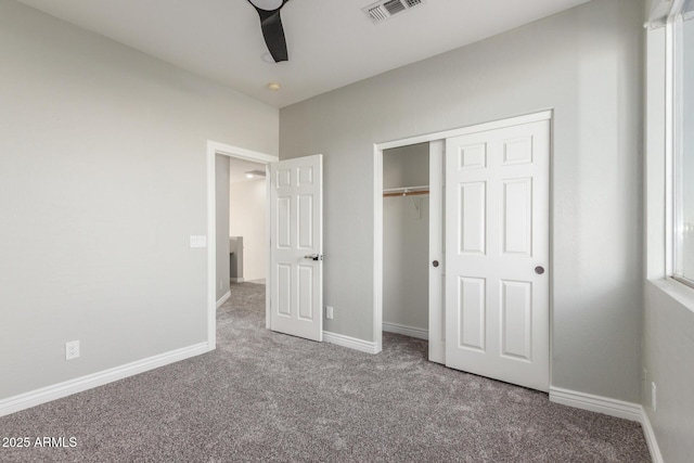 unfurnished bedroom with visible vents, baseboards, carpet floors, and a closet