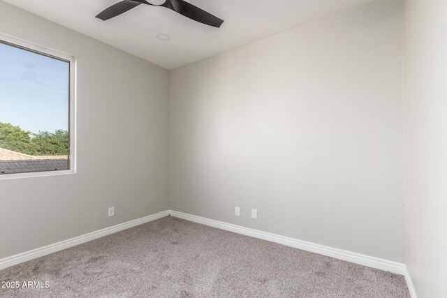 carpeted spare room with baseboards and ceiling fan