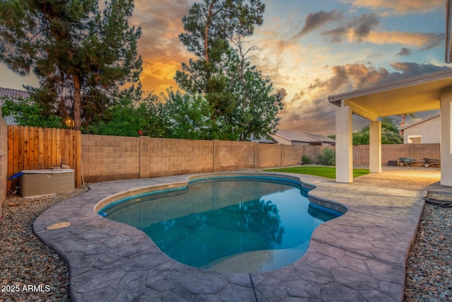 pool at dusk with a fenced backyard, a fenced in pool, and a patio
