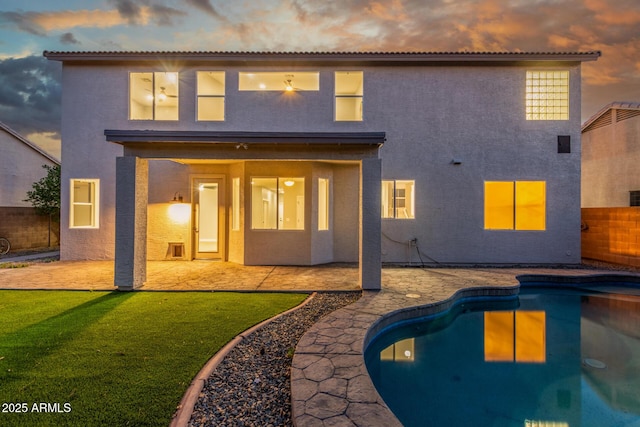 back of house featuring a fenced backyard, a patio area, stucco siding, and an outdoor pool