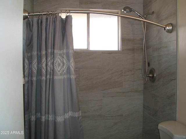 bathroom with toilet and a shower with shower curtain