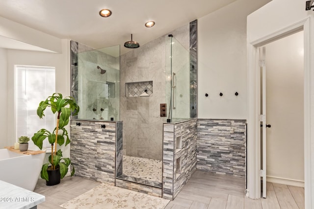 bathroom with a freestanding bath, a walk in shower, recessed lighting, and wood finished floors