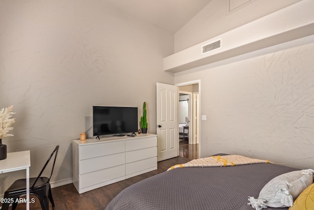 bedroom featuring lofted ceiling, dark wood-style flooring, and visible vents