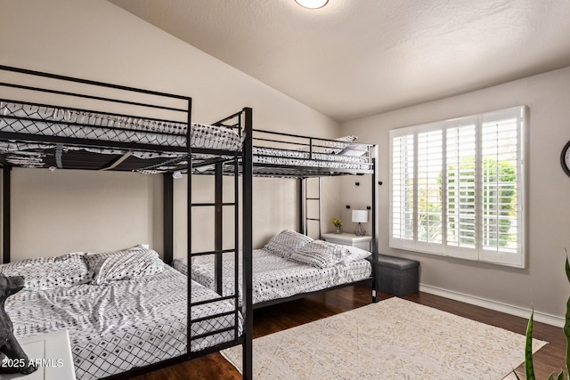 bedroom featuring baseboards, vaulted ceiling, and wood finished floors