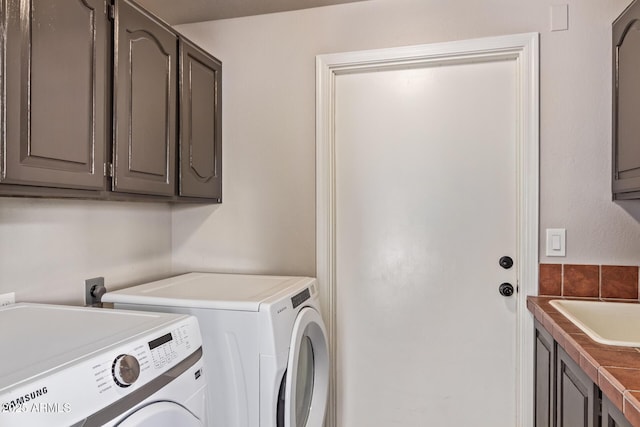 laundry room featuring cabinet space, independent washer and dryer, and a sink