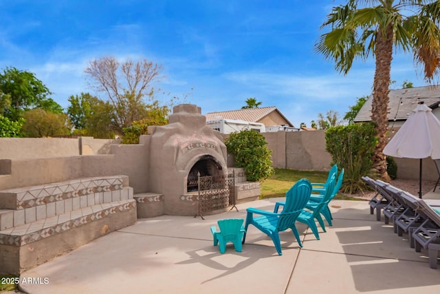 view of patio with a fenced backyard and exterior fireplace