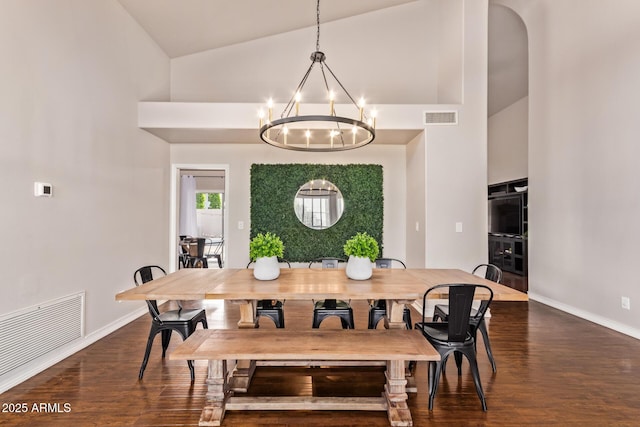 dining space featuring visible vents, baseboards, wood finished floors, and an inviting chandelier