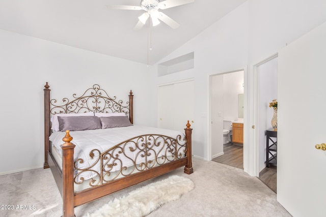 carpeted bedroom with high vaulted ceiling, ceiling fan, and ensuite bath