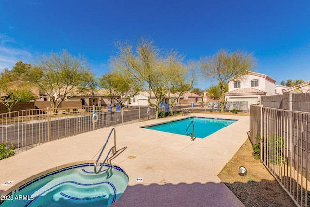 view of pool featuring a hot tub and a patio area