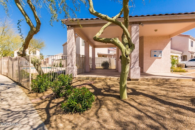 rear view of property with a patio and a fenced in pool