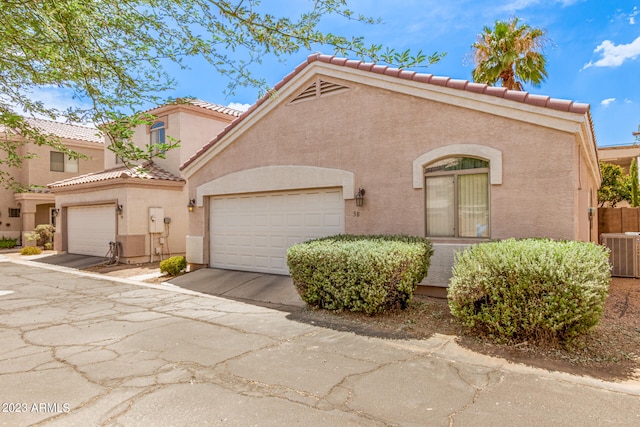 mediterranean / spanish-style house with a garage and central AC