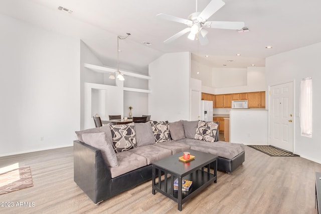 living room featuring high vaulted ceiling, light hardwood / wood-style floors, and ceiling fan