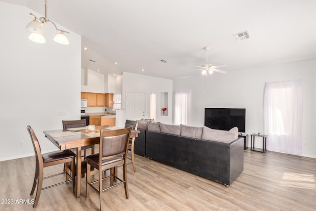 dining room with light hardwood / wood-style floors, lofted ceiling, sink, and ceiling fan